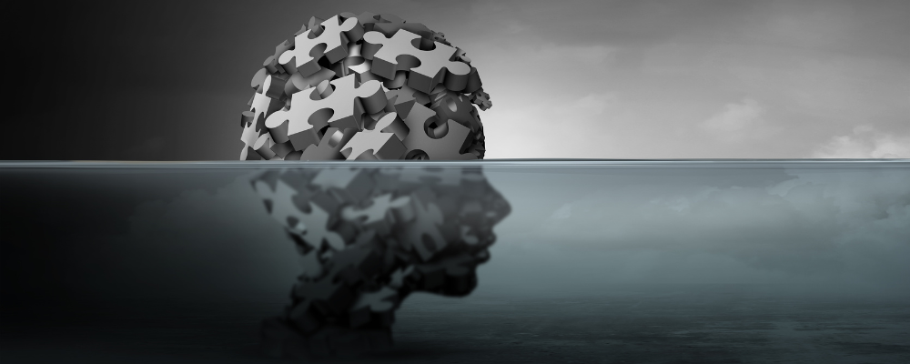 head made out of puzzle pieces submerged in water
