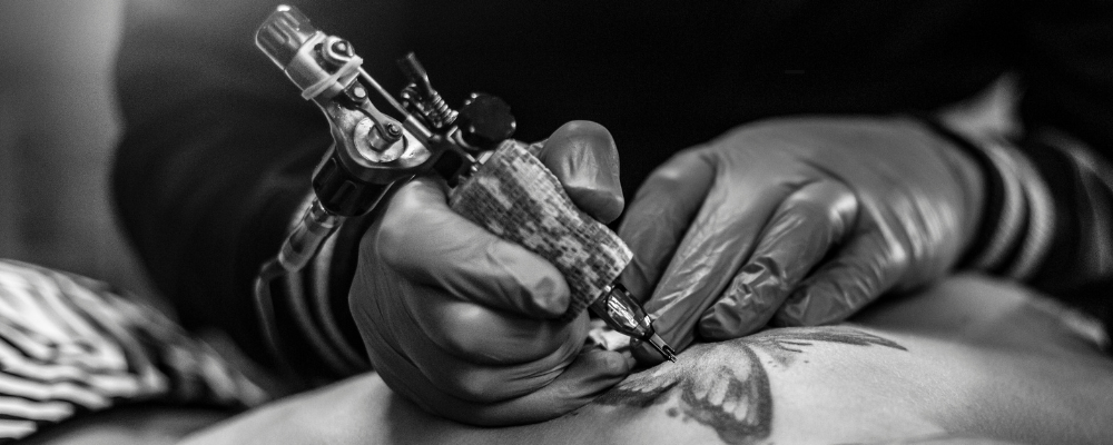 Tattoo artist working on a detailed design, symbolizing how tattoos can serve as personal expressions or coping tools for individuals living with anxiety.