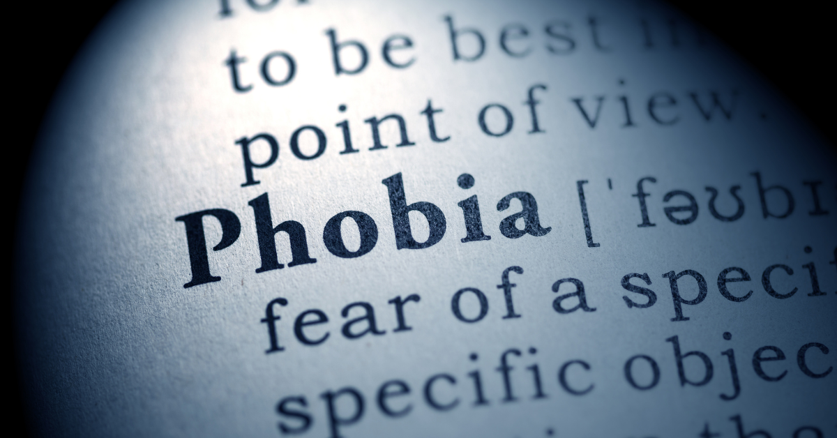 A close-up of a dictionary page with the word "Phobia" highlighted. The definition below begins with "fear of a specific object."