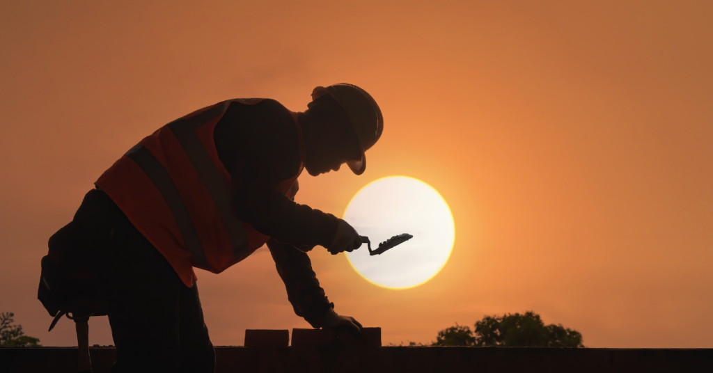 silhouette of a construction worker with the sunset in the background