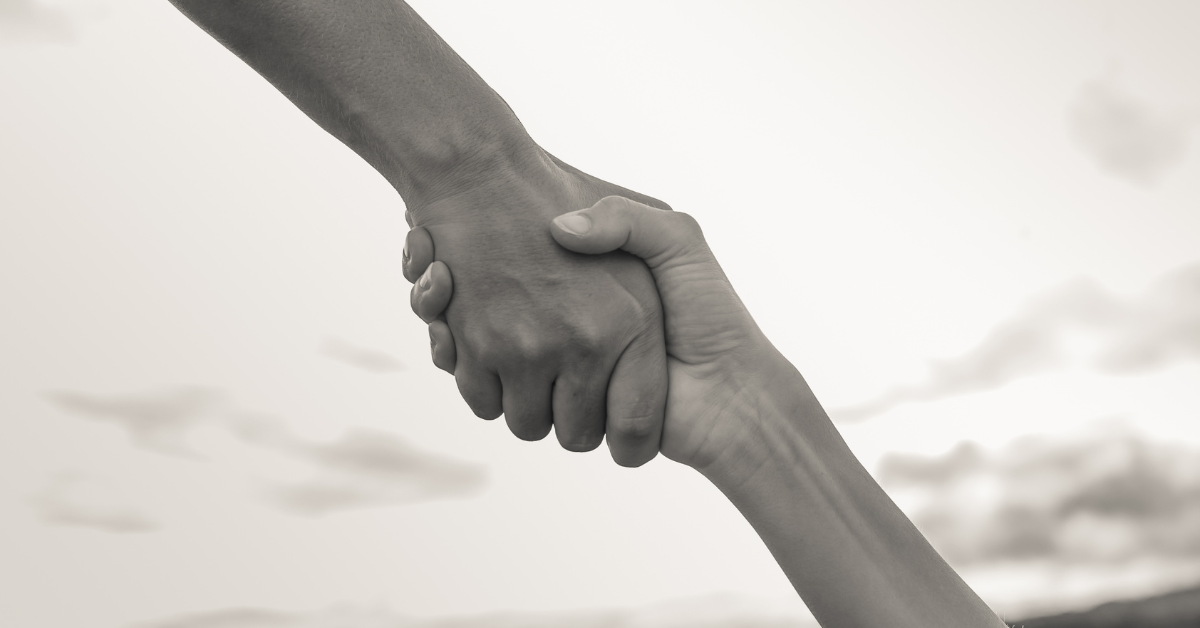 Two hands reaching out to each other, symbolizing support, help, or unity.