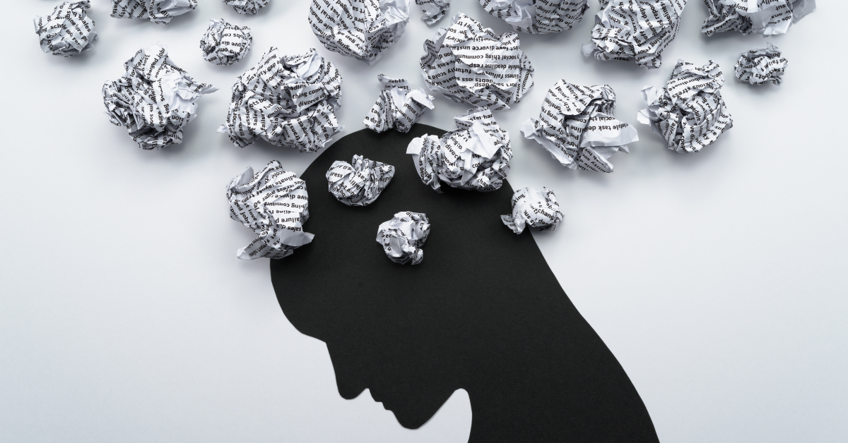 The image shows a silhouette of a person's head filled with crumpled paper balls, suggesting mental clutter or overwhelming thoughts.