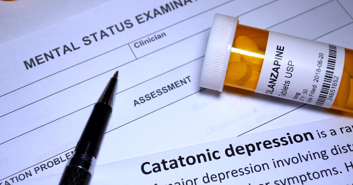 Closeup of a prescriptions and paper with the word 'catatonic depression'