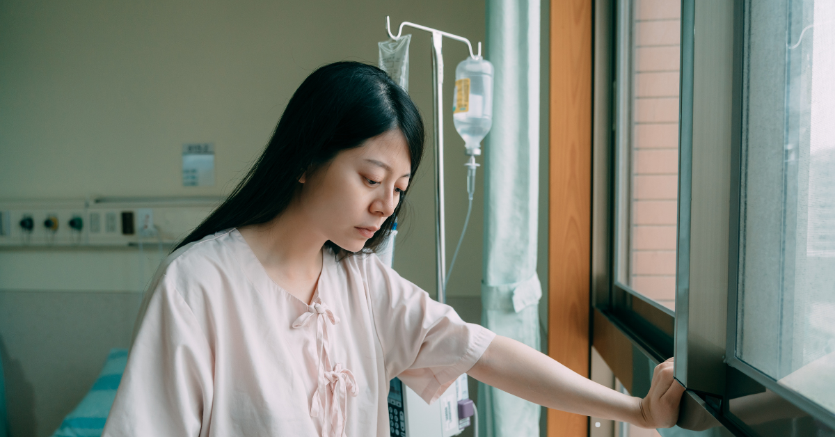 A woman in a hospital with a sad expression.